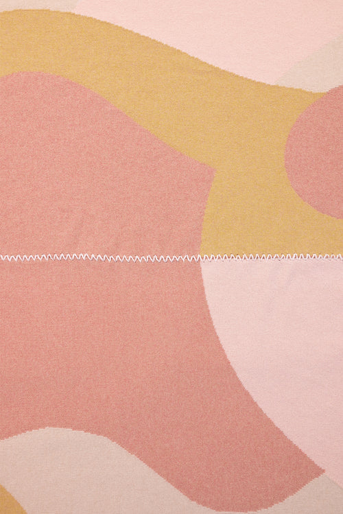 stitch detail of abstract knit blanket with hand-stitched seam in pink, yellow and beige wool