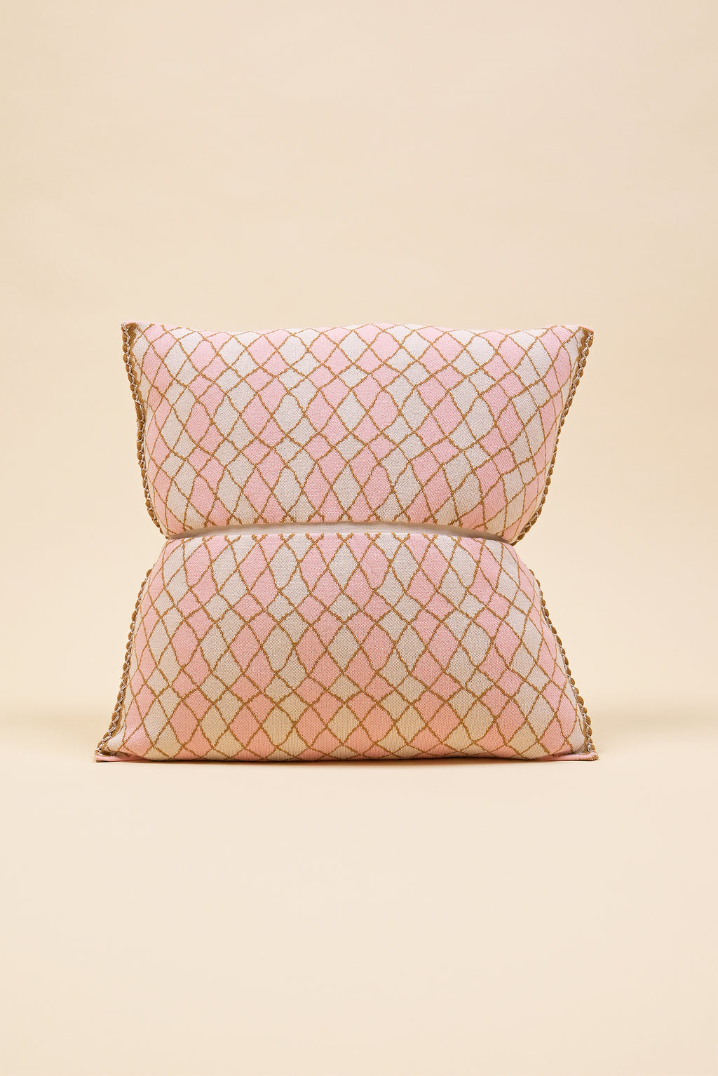 front side of pink bow-shaped knit pillowcase with romb pattern in viscose on beige background