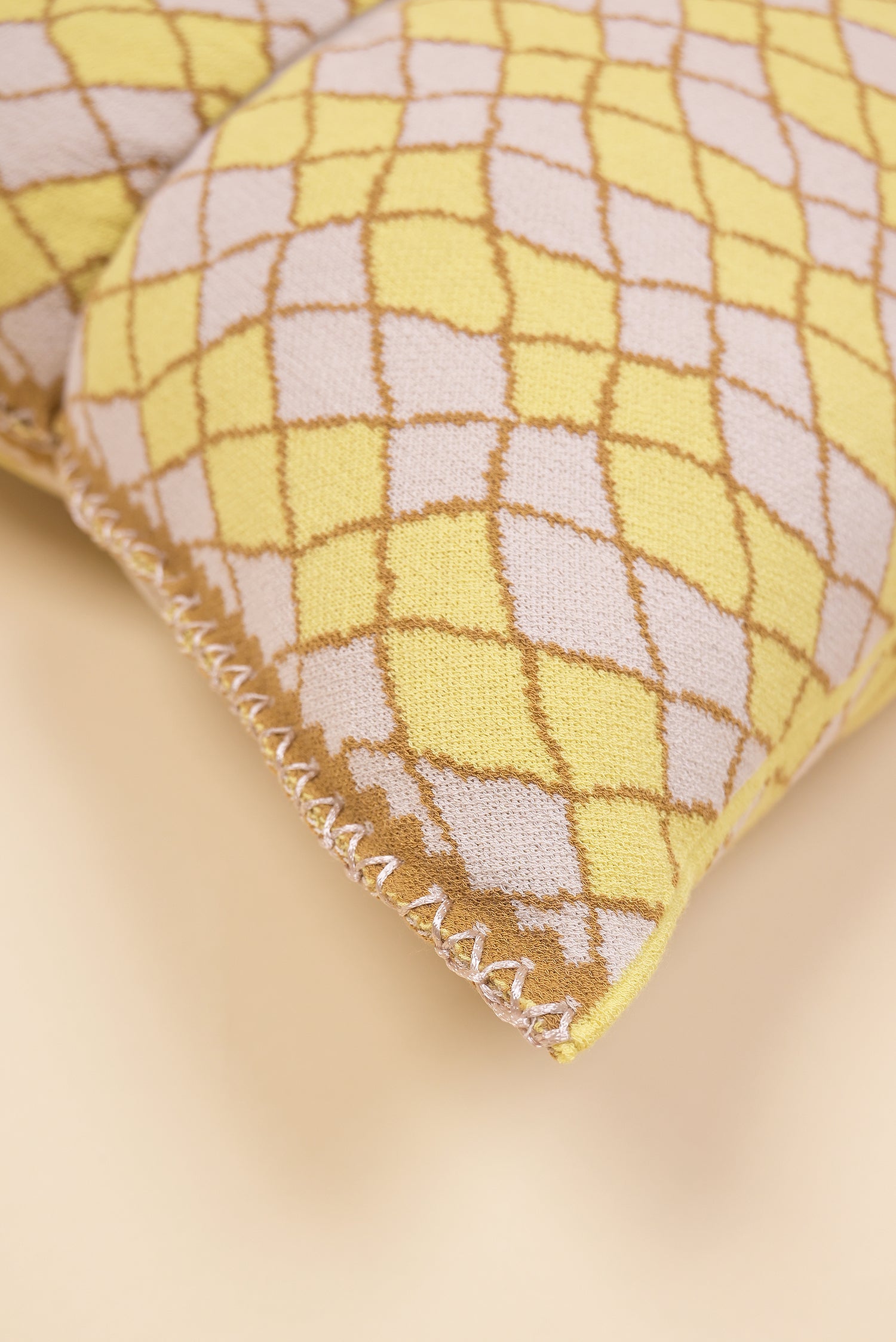 corner detail of bow-shaped knit pillowcase with romb pattern in viscose