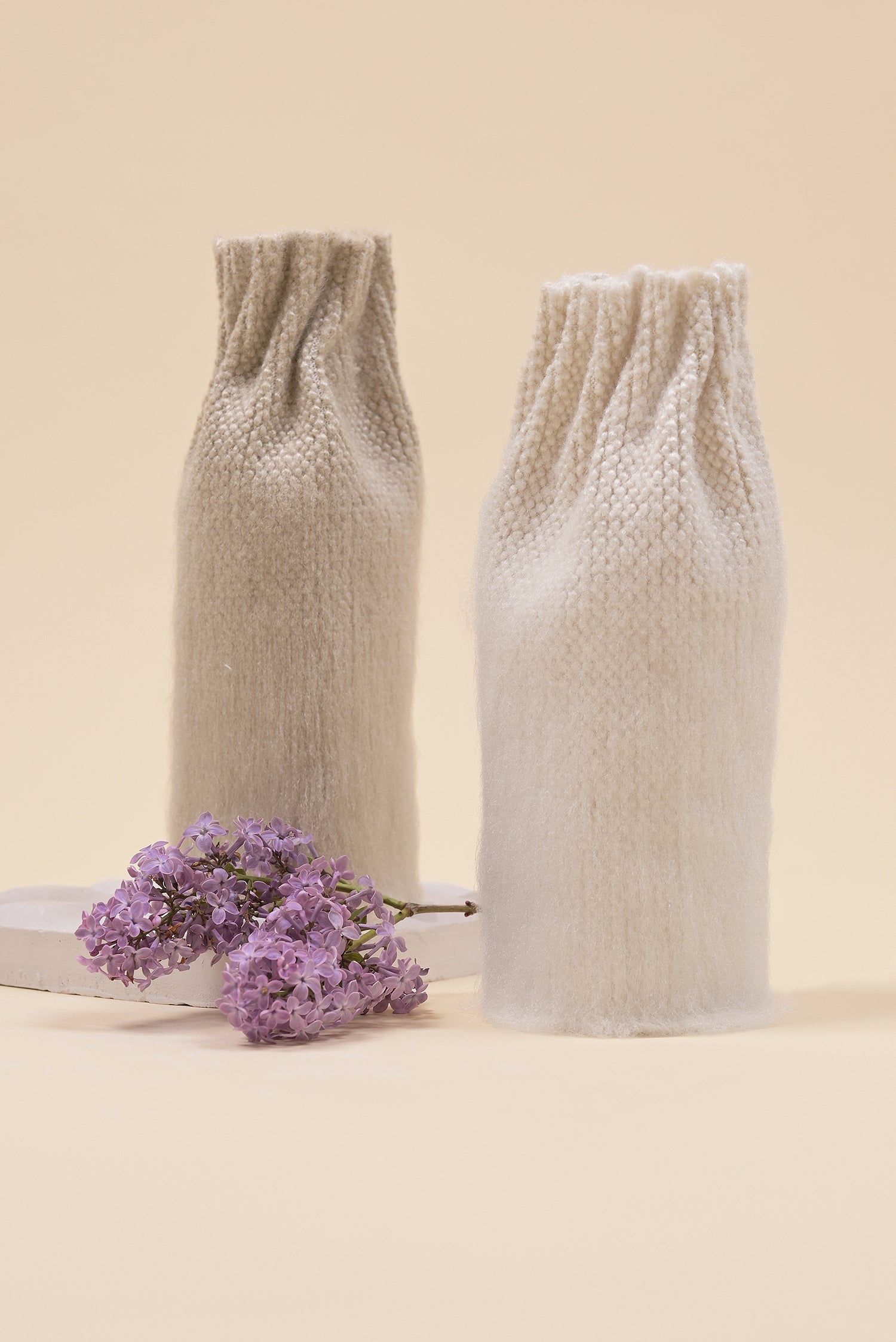 front view of beige knit textile vase in brushed silk and organic cotton displayed 
