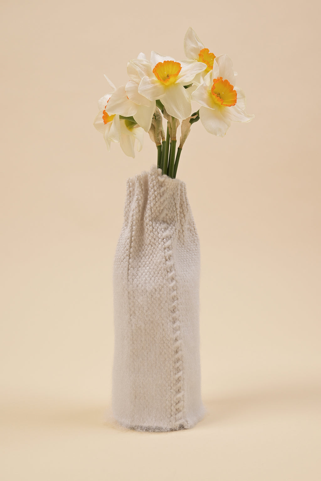 back side of off-white knit textile vase in brushed silk and organic cotton with flower