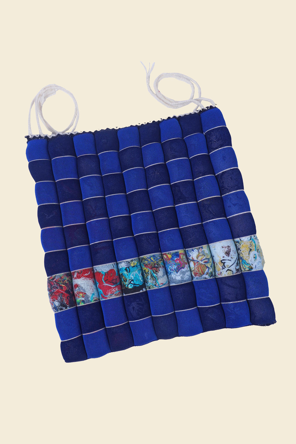 front view of blue/navy knit checkered seat cushion with upcycled materials with beige background 