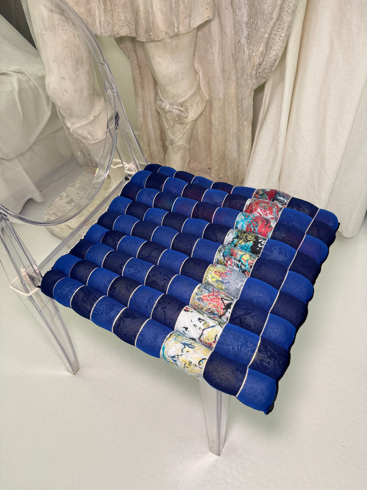 [blue/navy][open] blue and navy checkered seat cushion shown from above on a grey background