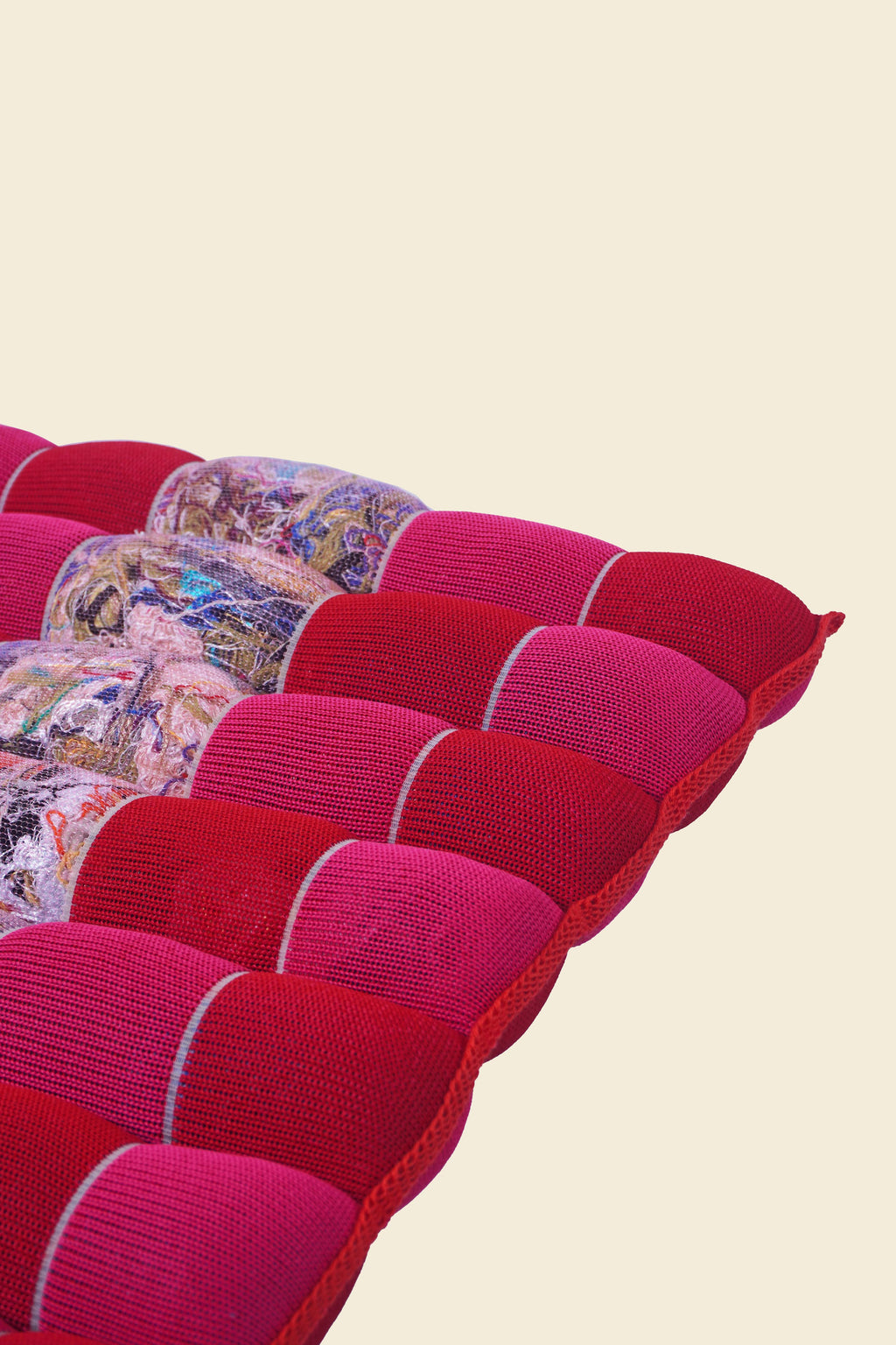 corner of red/pink knit checkered seat cushion with upcycled materials