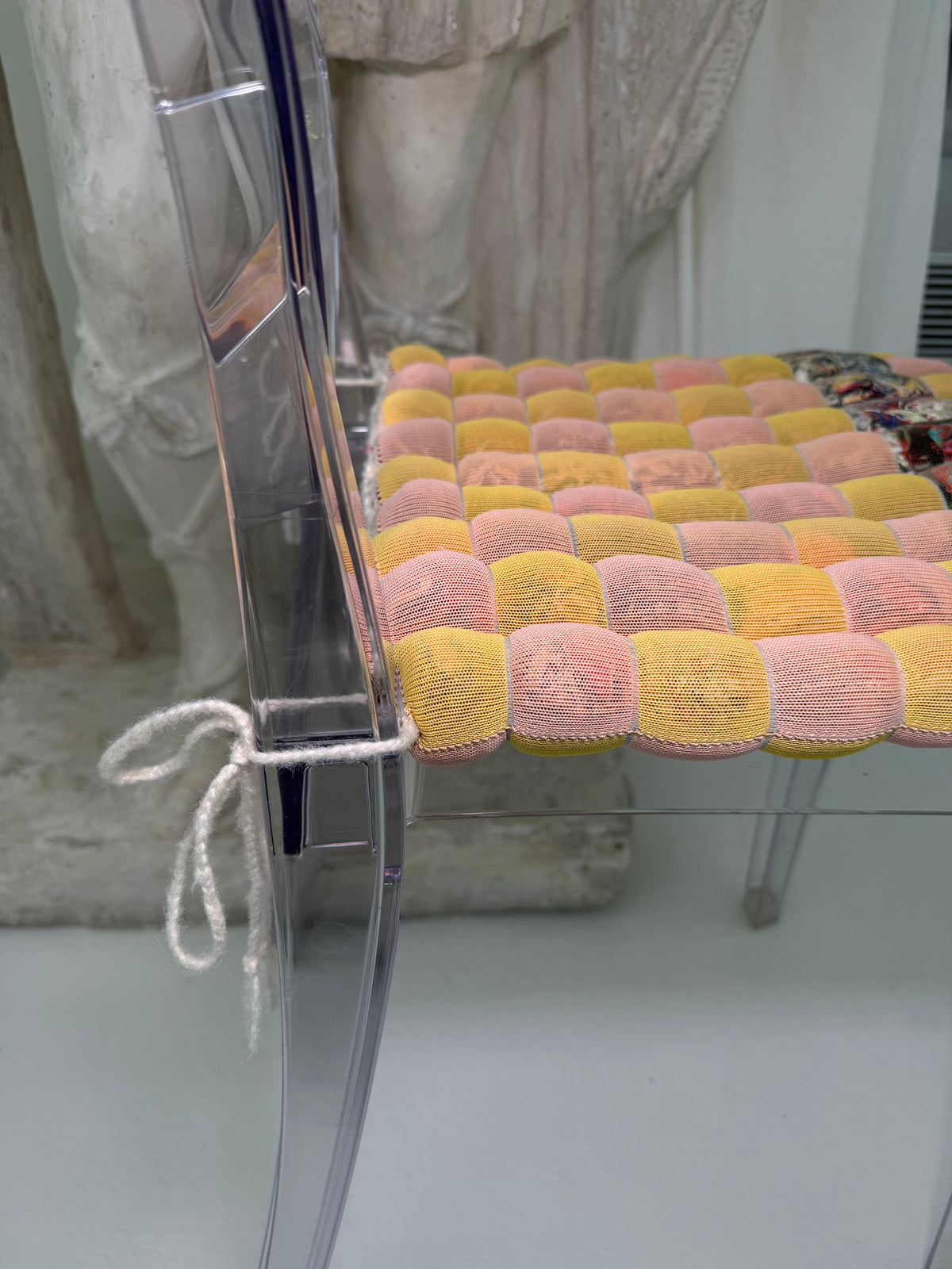 [yellow/pink][open] yellow and pink checkered seat cushion shown from above on a grey background