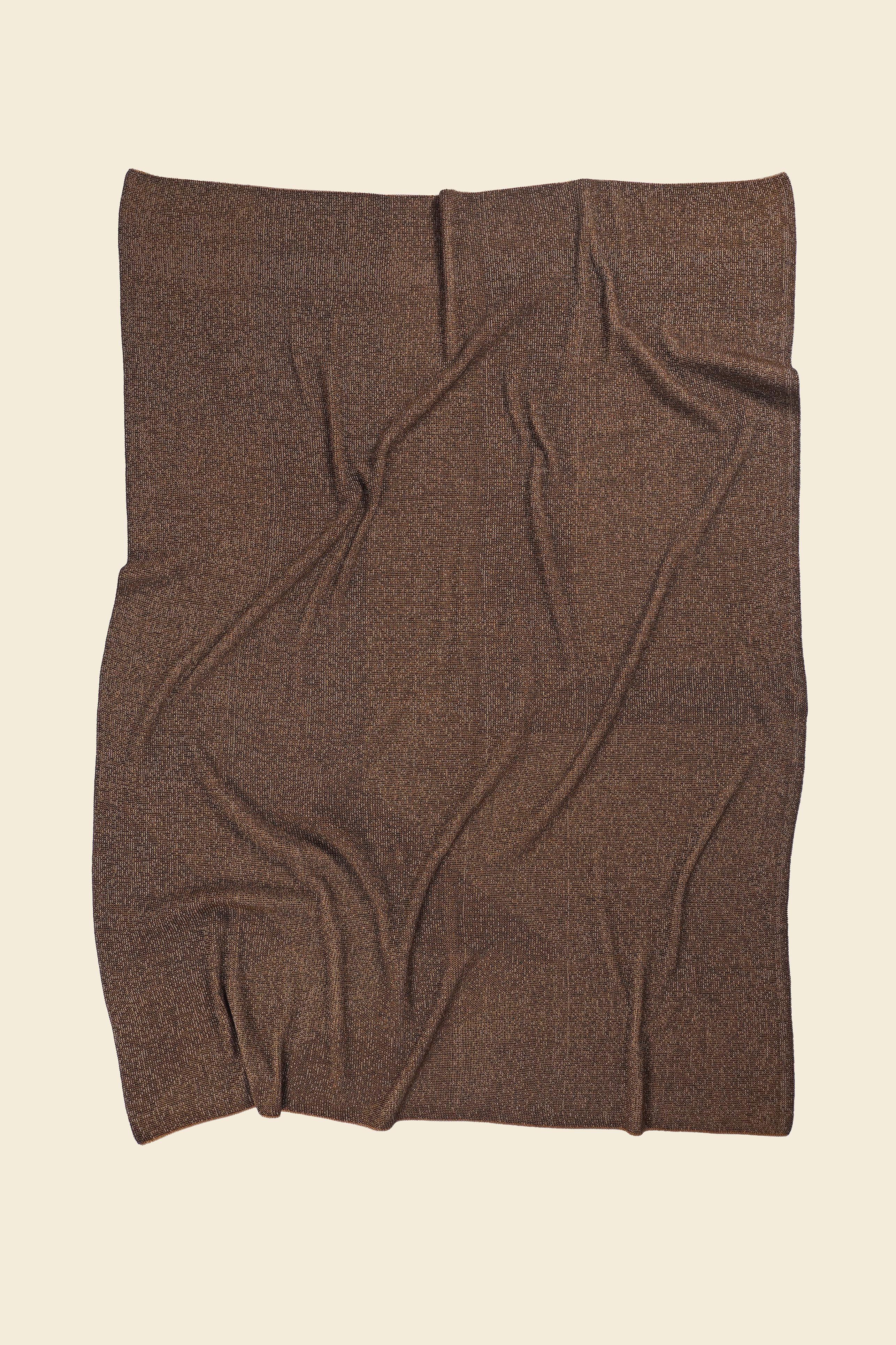 back side of brown/gold geometric ikat knit blanket in merino wool and organic cotton