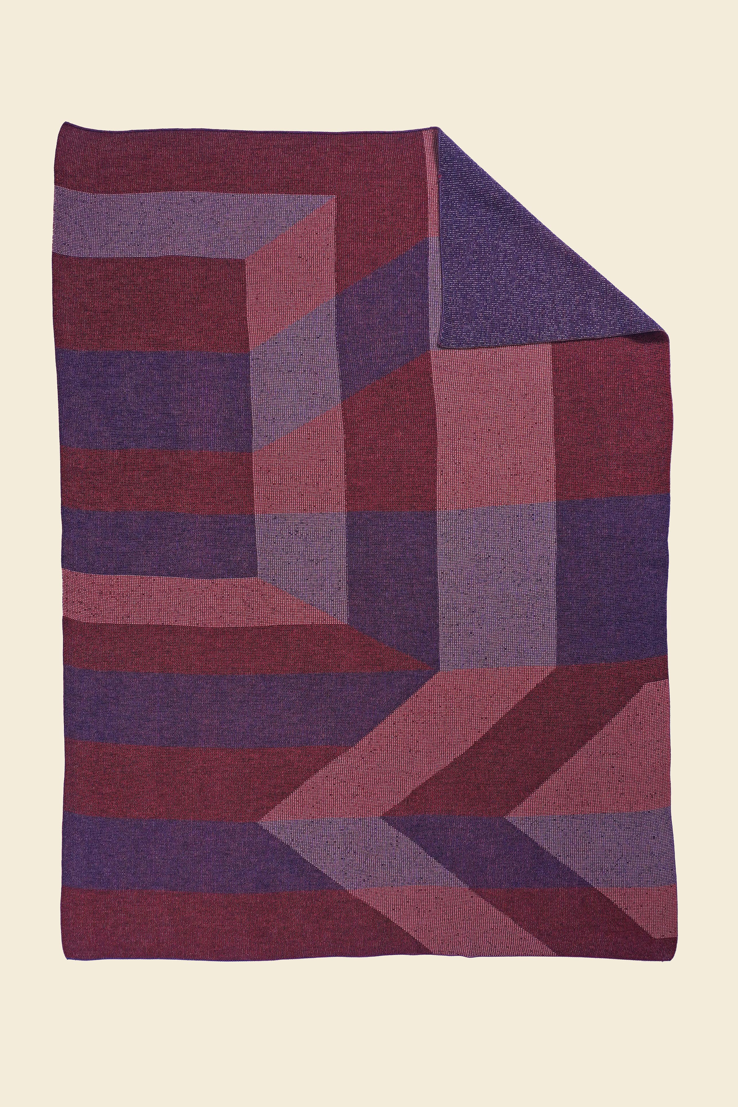 red/purple geometric ikat knit blanket with flipped corner in merino wool and organic cotton