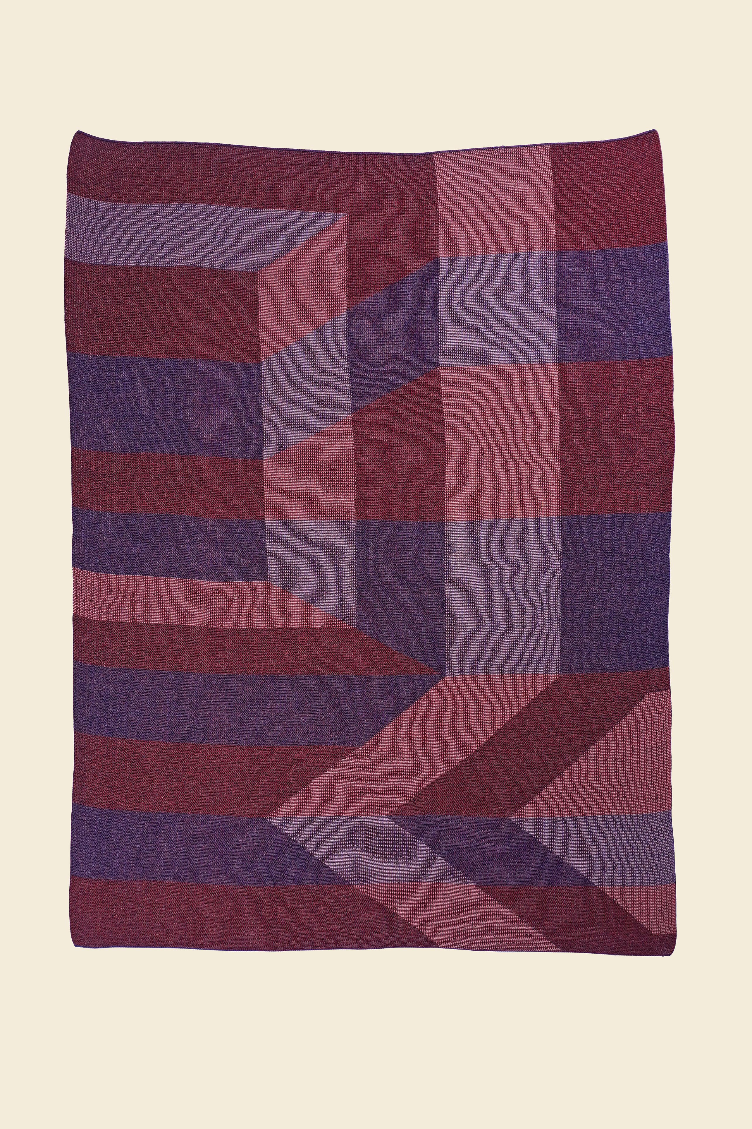 laid flat red/purple geometric ikat knit blanket in merino wool and organic cotton