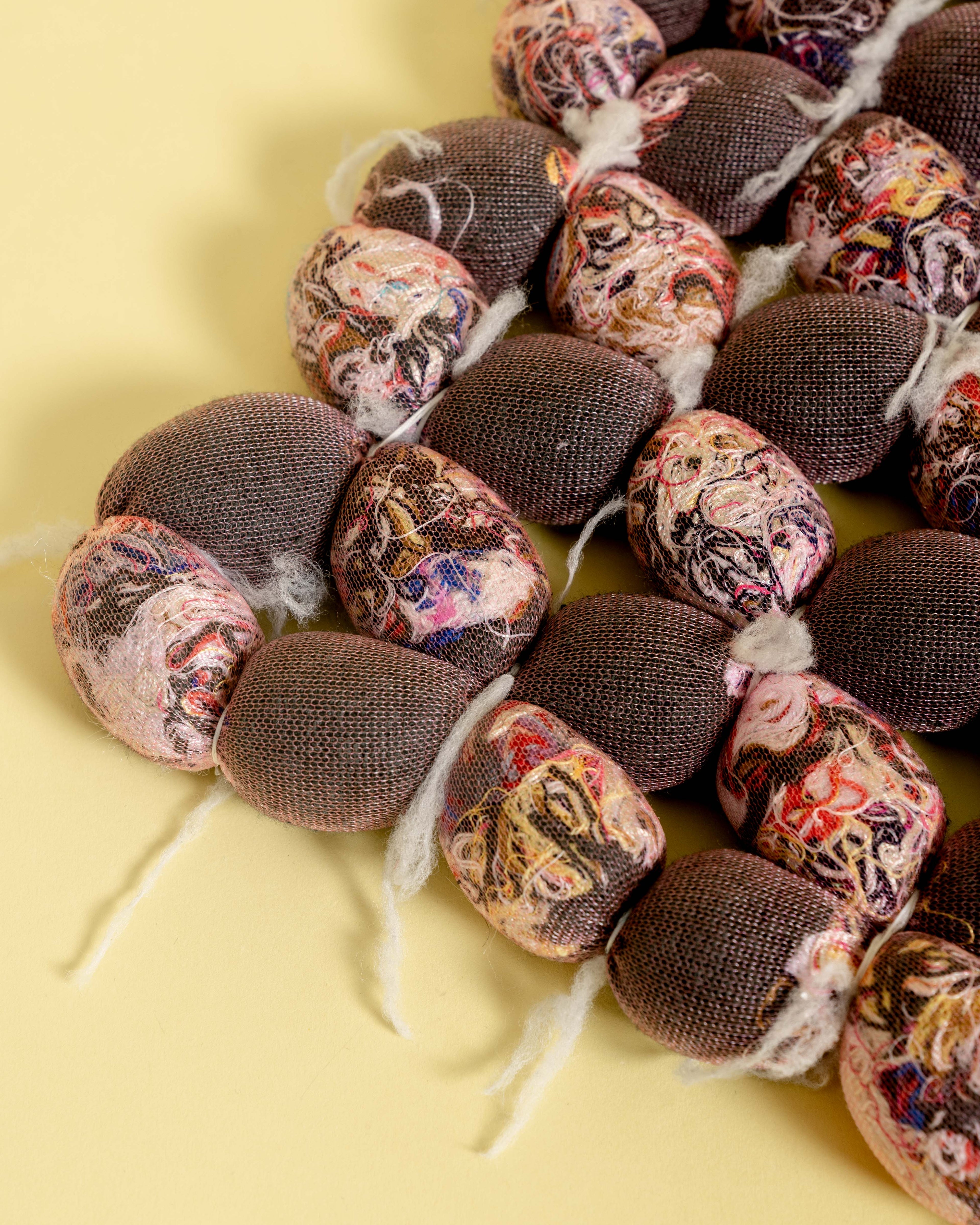 corner of hand-knotted knit seat cushion with transparent cover filled with upcycled materials