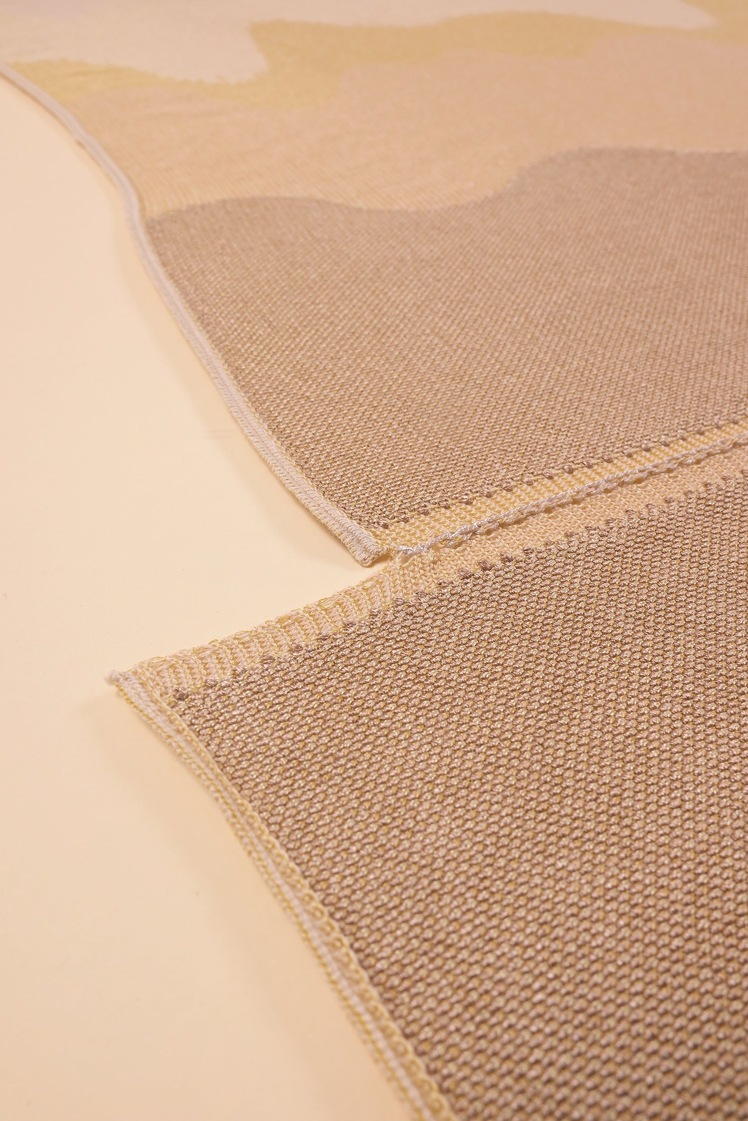 bottom detail of organic cotton knit tablecloth with hand-stitched seam in yellow monochrome tones