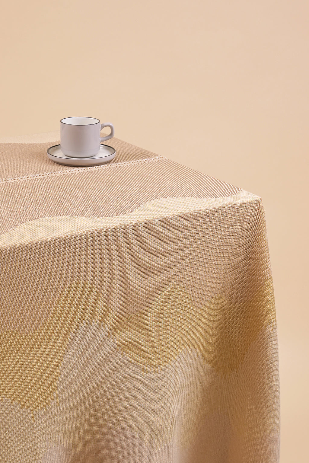 close-up of organic cotton knit tablecloth with hand-stitched seam in yellow monochrome tones