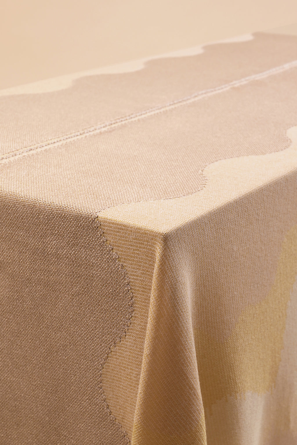 detail of organic cotton knit tablecloth with hand-stitched seam in yellow monochrome tones