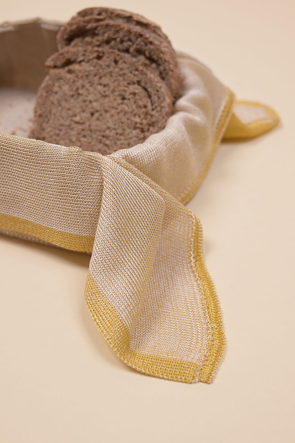detail of yellow and beige organic cotton, hemp and viscose knit bread basket