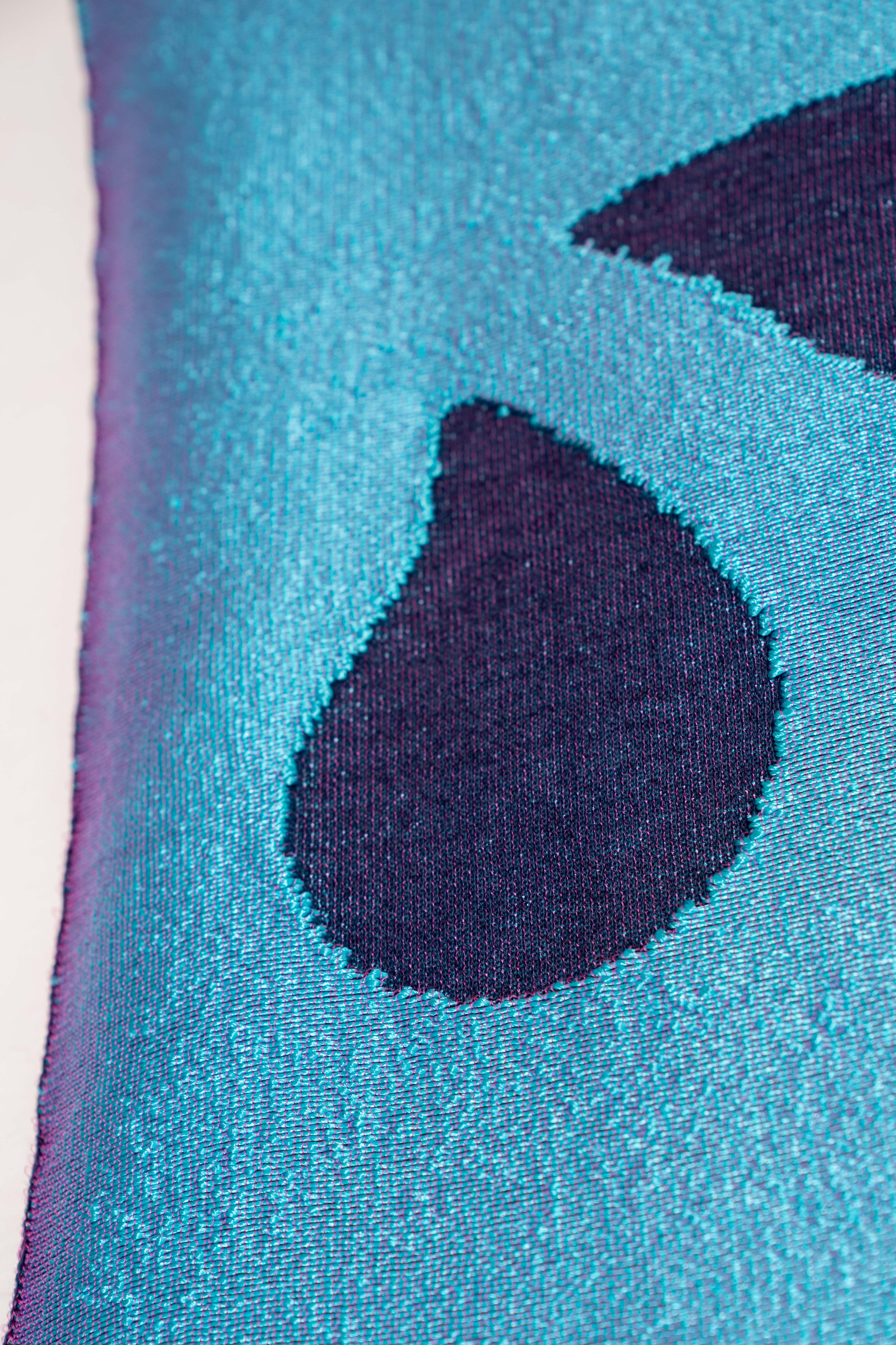 detail of blue knit wall hanging with wooden magnetic frame