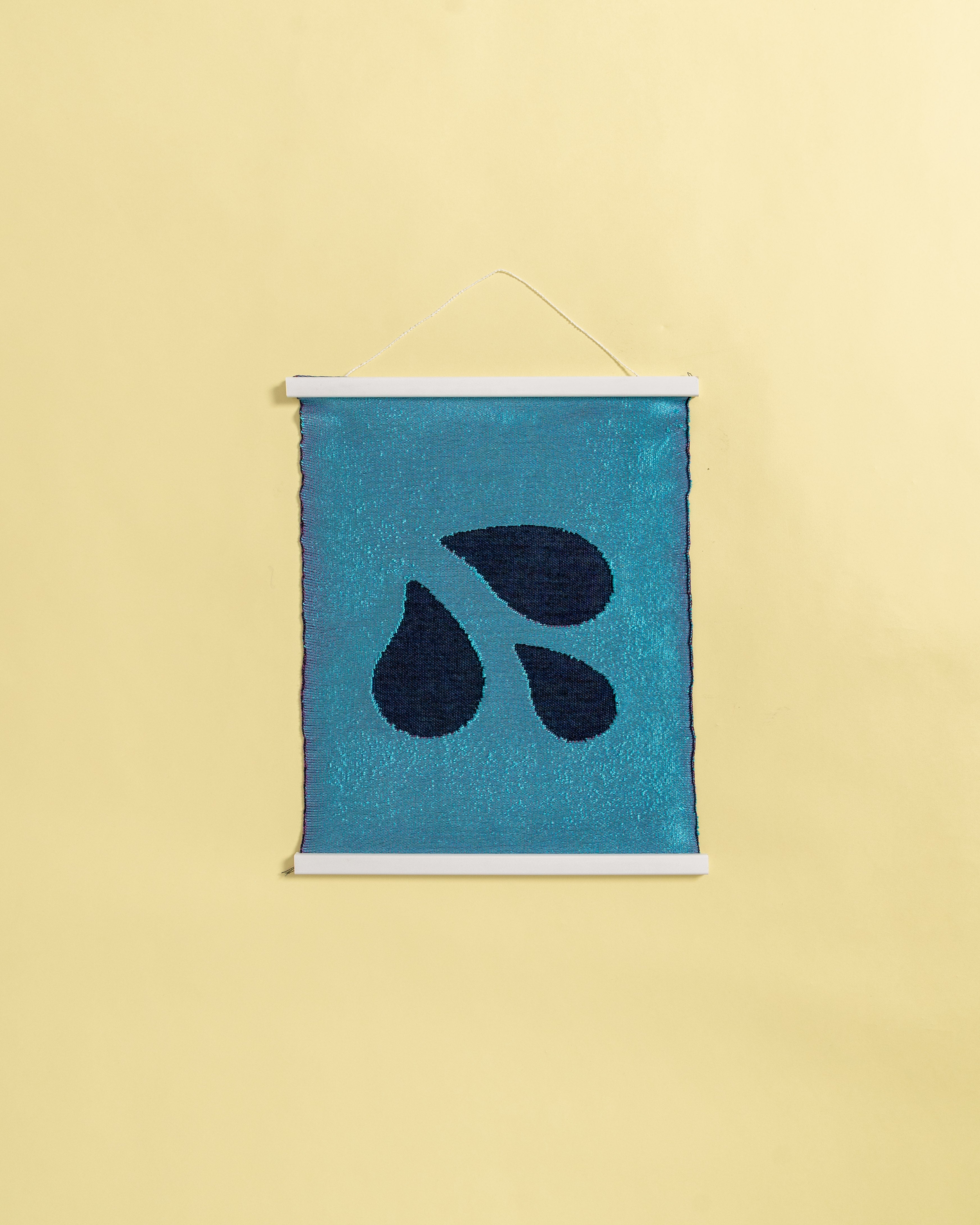 front view of blue knit wall hanging with wooden magnetic frame on background