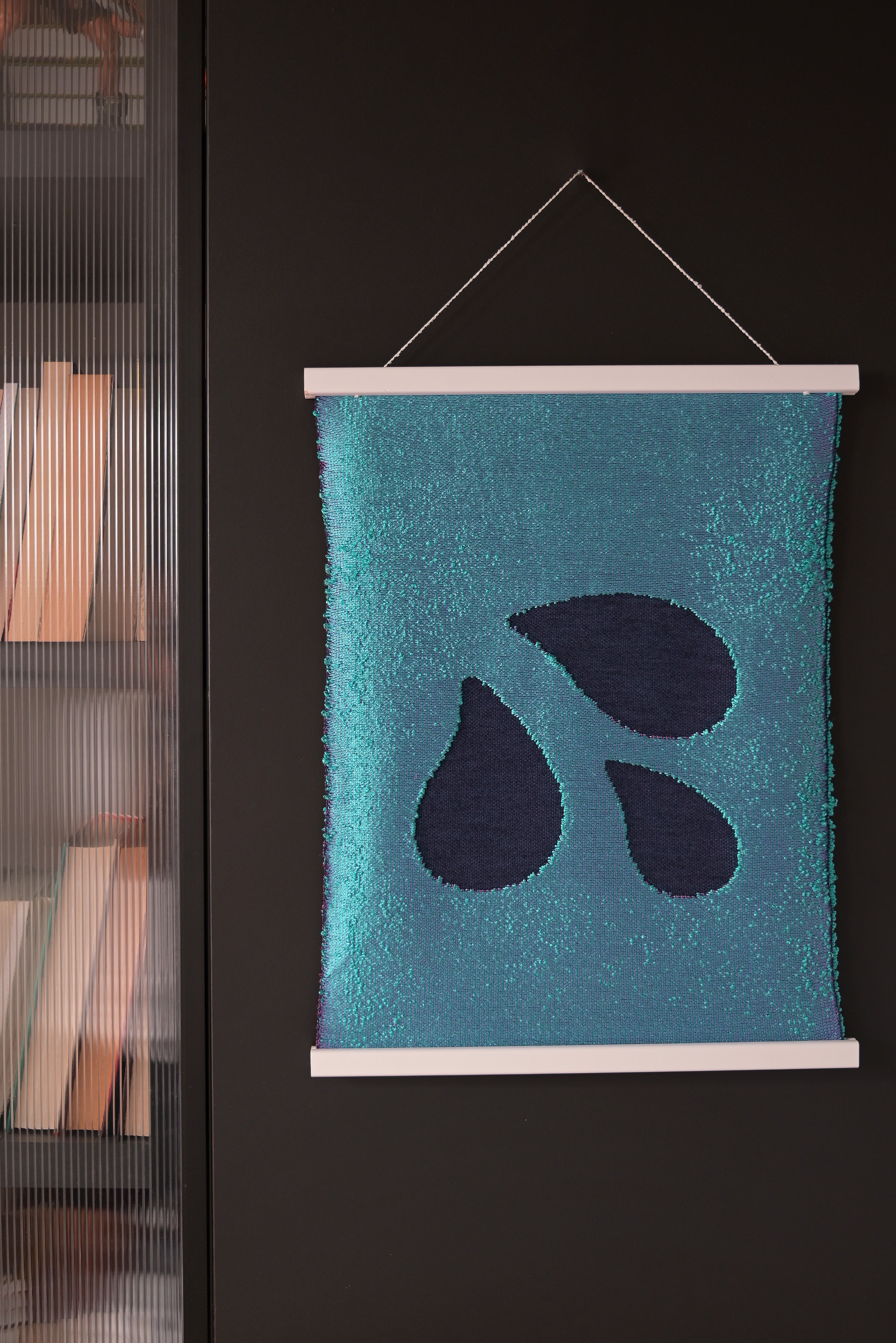 front view of blue knit wall hanging with wooden magnetic frame displayed