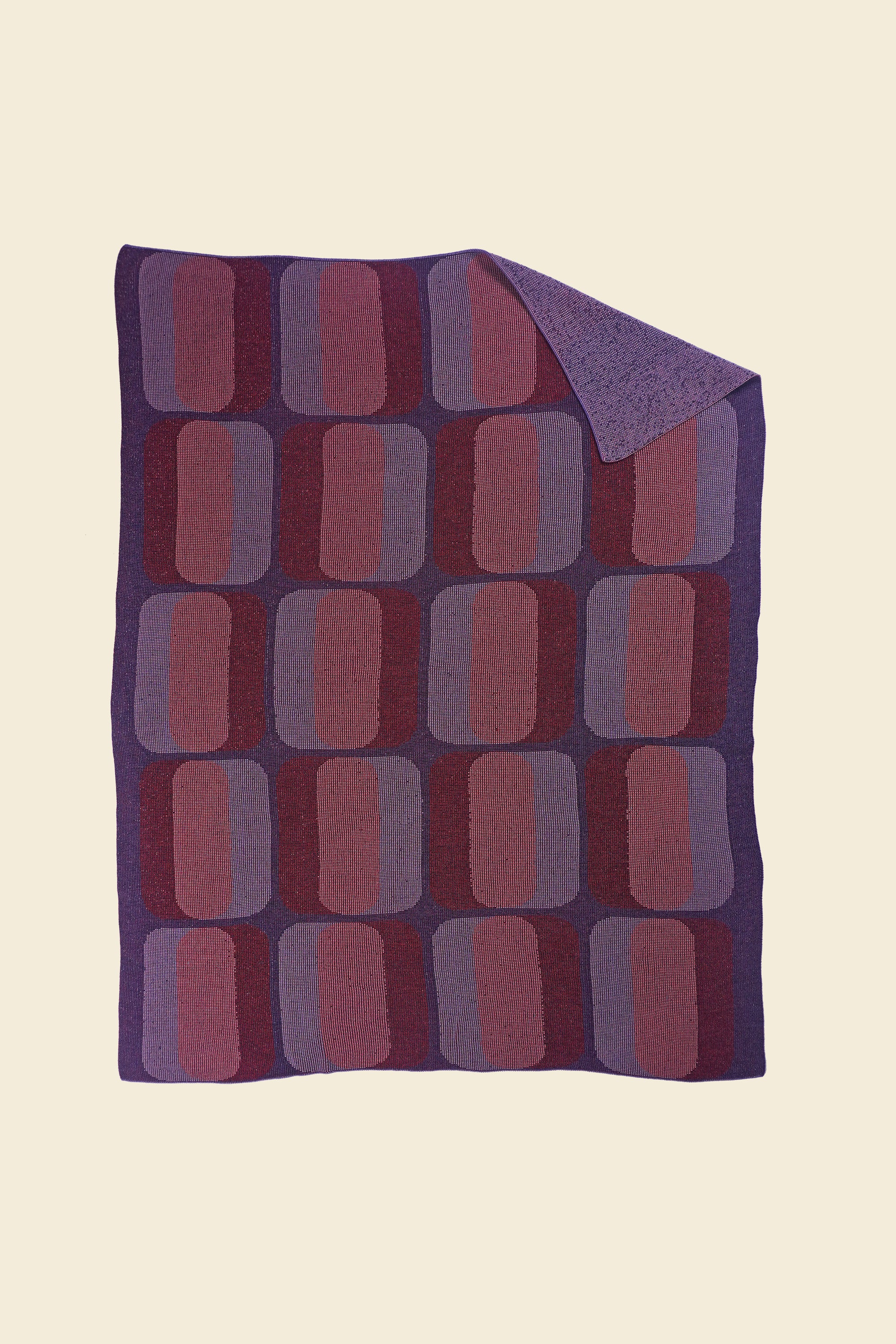 red/purple geometric knit blanket with flipped corner in merino wool and organic cotton