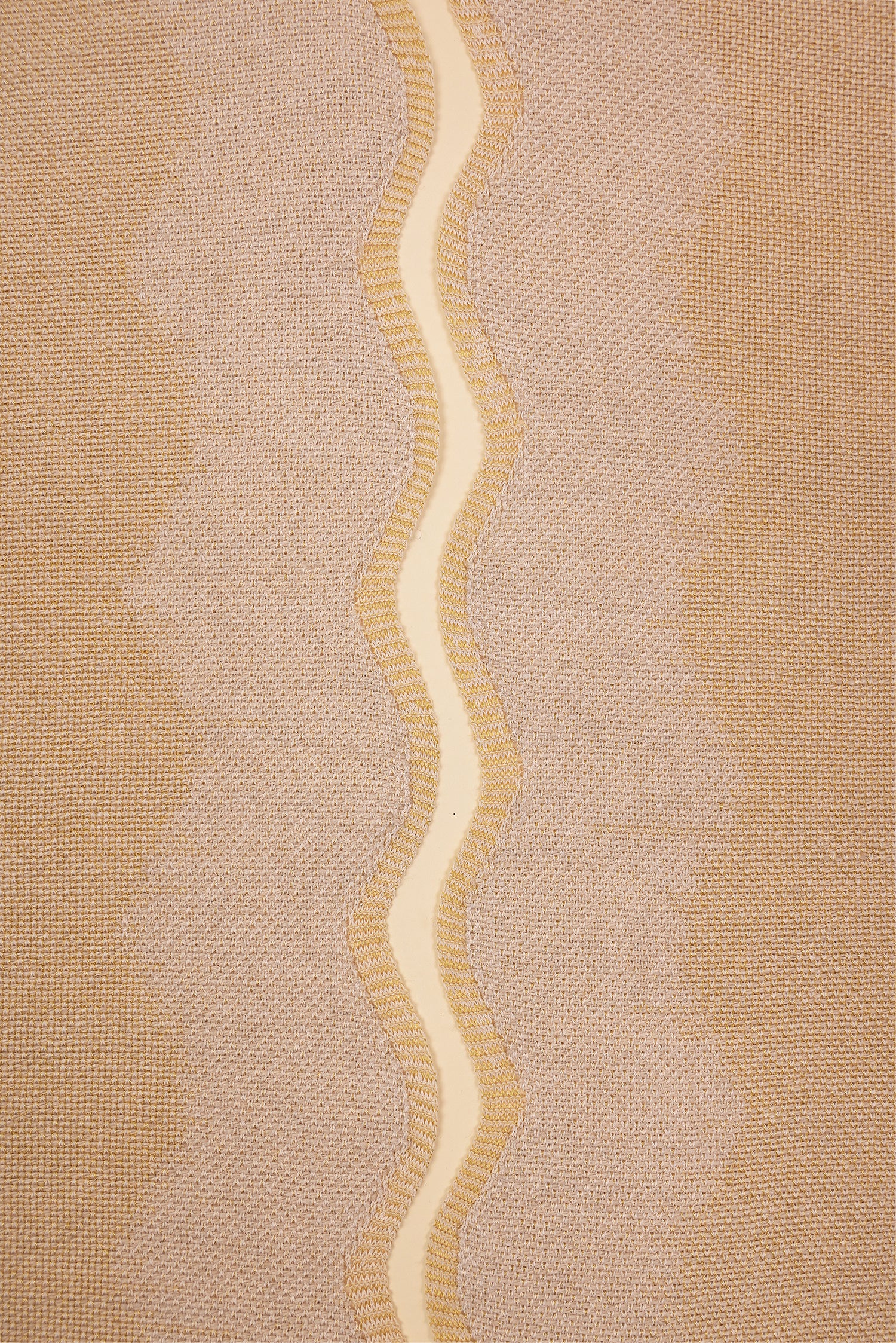 detail of beige and yellow knit organic cotton and hemp table mat with wavy pattern