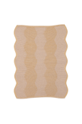 top view of beige and yellow knit organic cotton and hemp table mat with wavy pattern