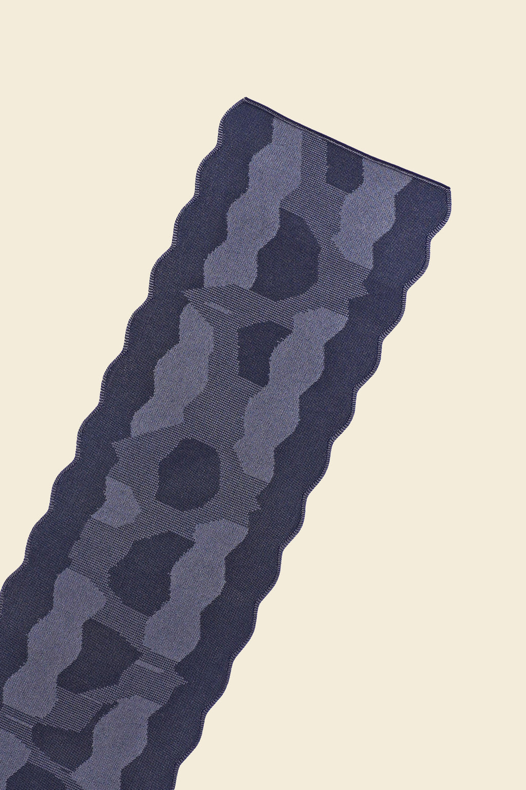 top close-up of grey knit organic cotton and viscose table runner with abstract pattern and wavy edges