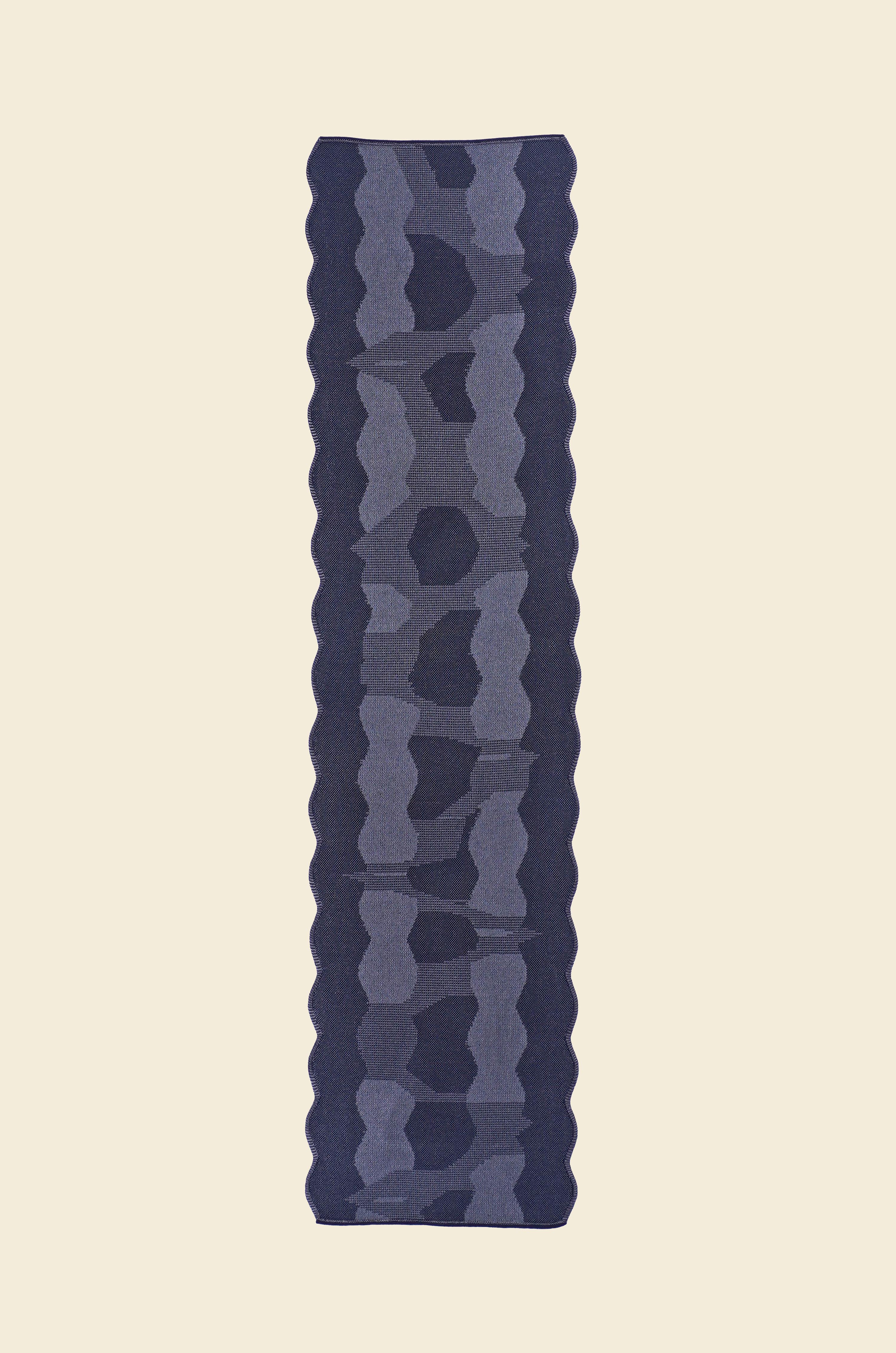 top view of grey knit organic cotton and viscose table runner with abstract pattern and wavy edges