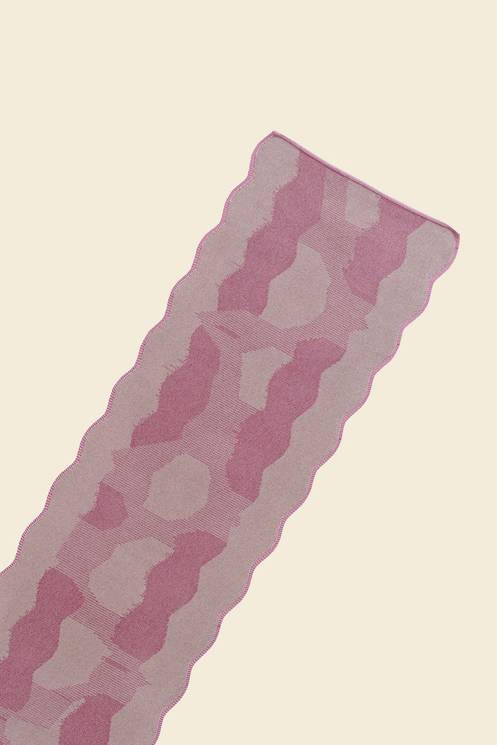 top close-up of pink knit organic cotton and viscose table runner with abstract pattern and wavy edges