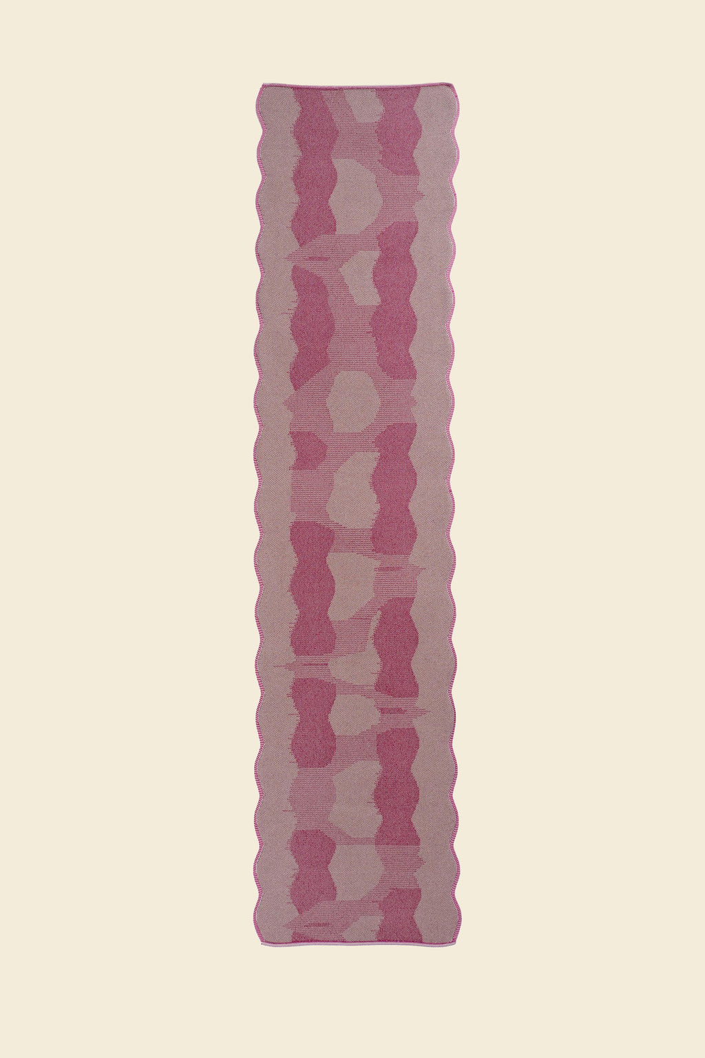 top view of pink knit organic cotton and viscose table runner with abstract pattern and wavy edges