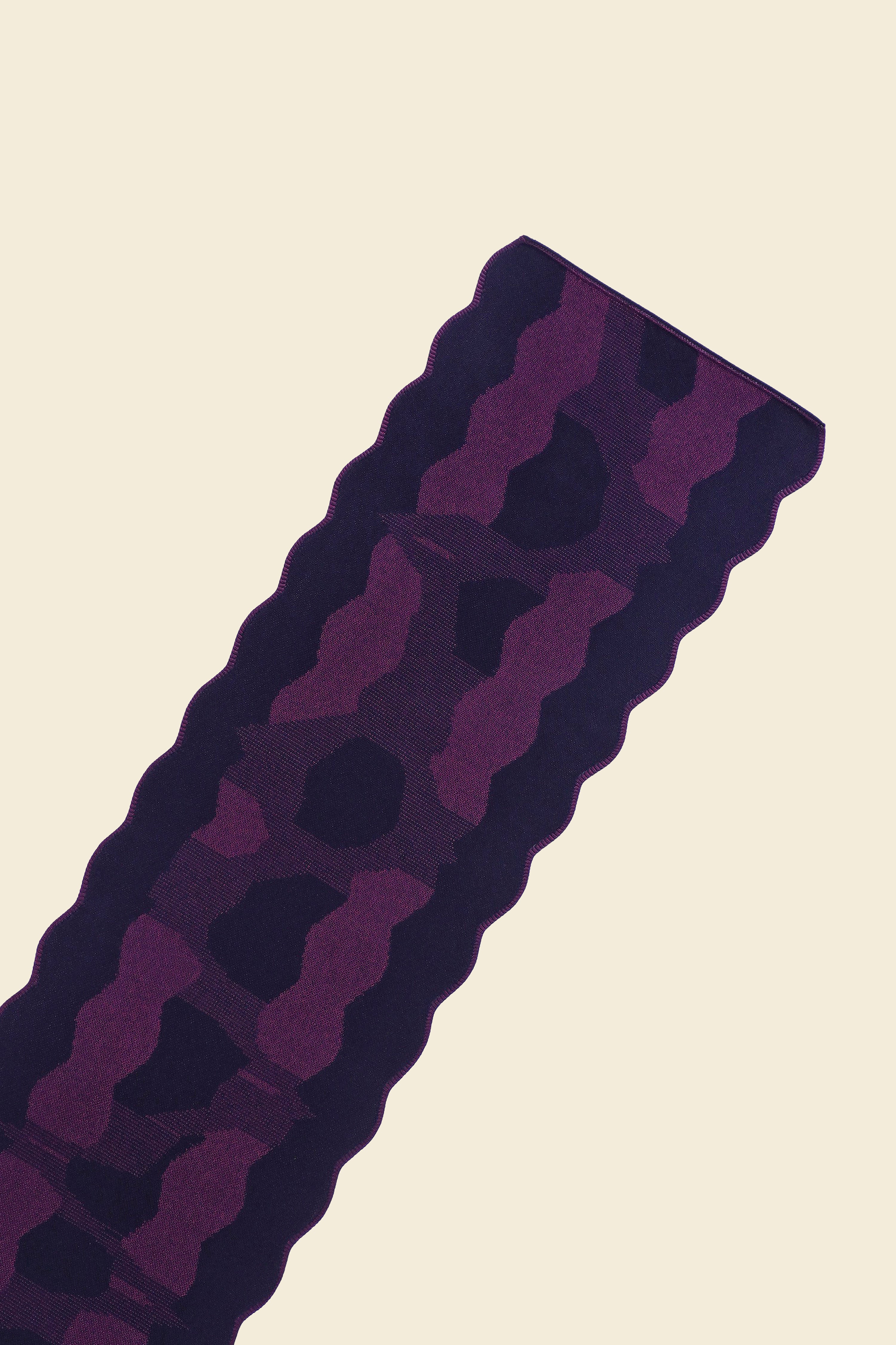 top close-up of purple knit organic cotton and viscose table runner with abstract pattern and wavy edges