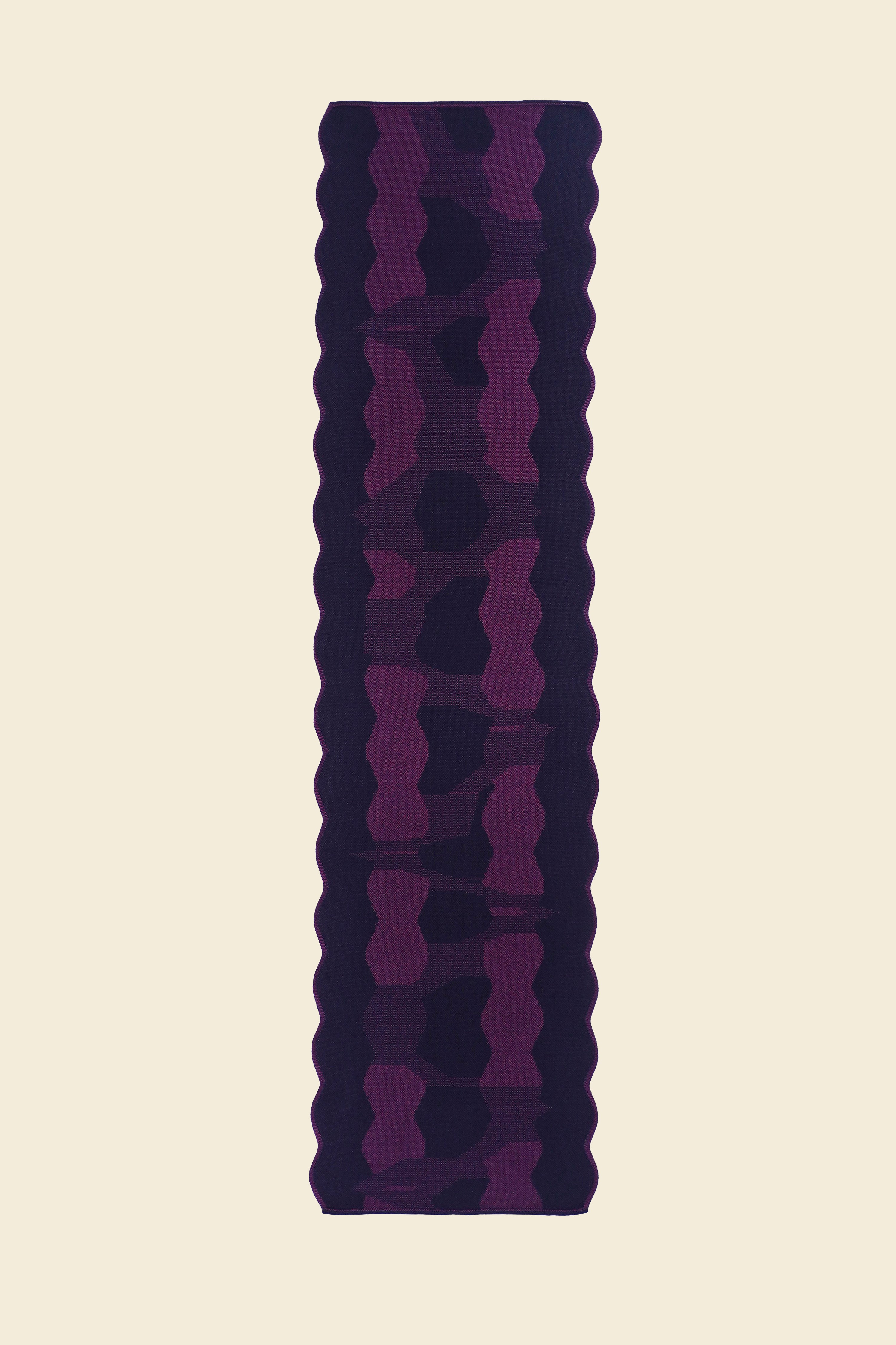 top view of purple knit organic cotton and viscose table runner with abstract pattern and wavy edges