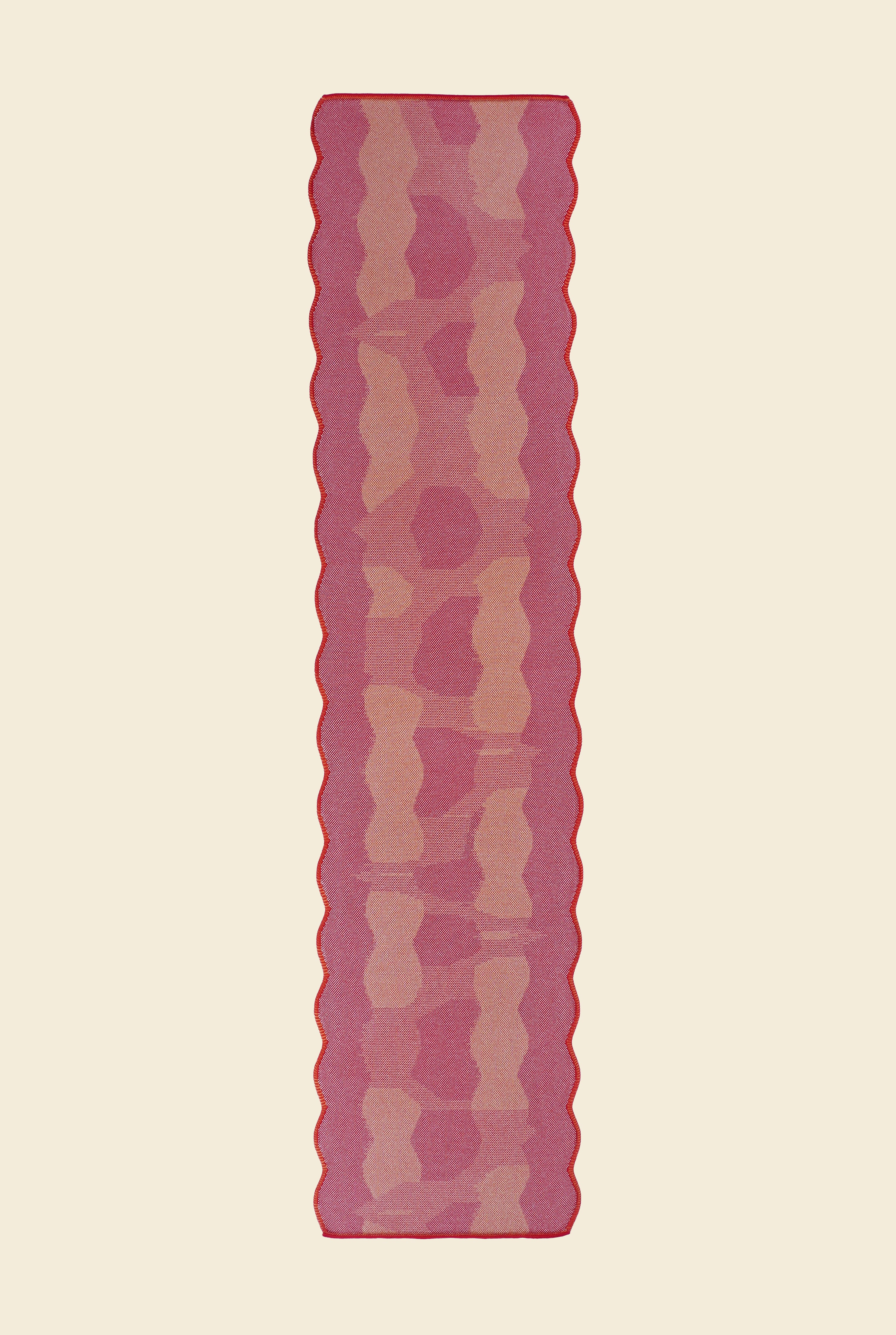 top view of red knit organic cotton and viscose table runner with abstract pattern and wavy edges