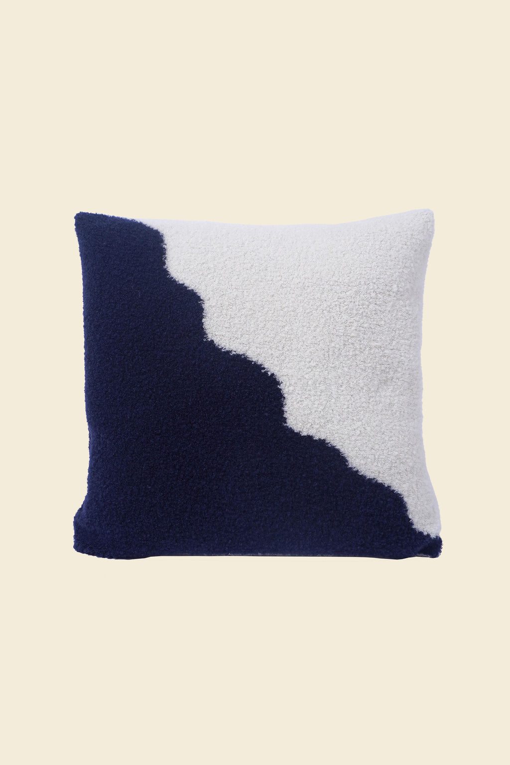 front side of off-white/navy knit plush pillowcase in viscose and merino wool on beige background