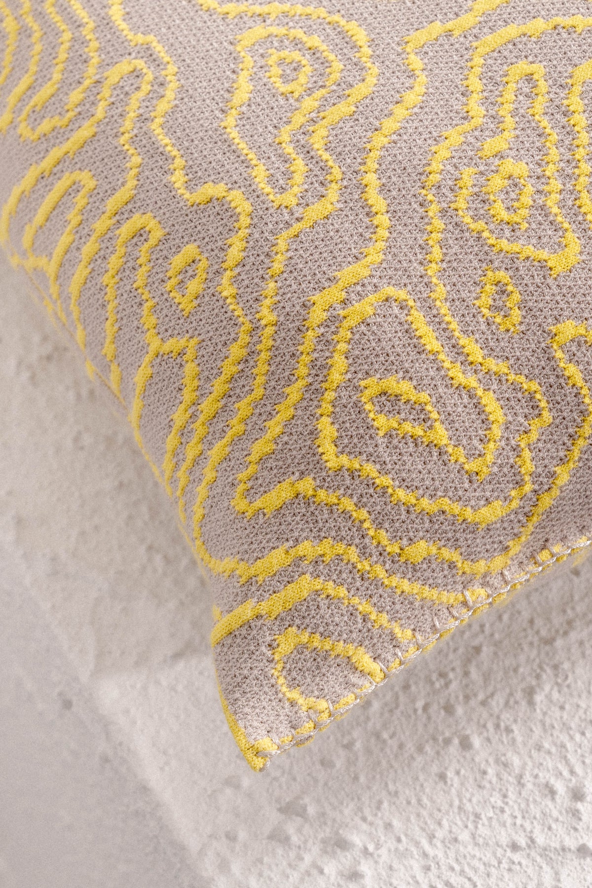 [yellow/beige] close-up of the organic curves pattern and corner stitching on the yellow/beige soft viscose knit pillowcase