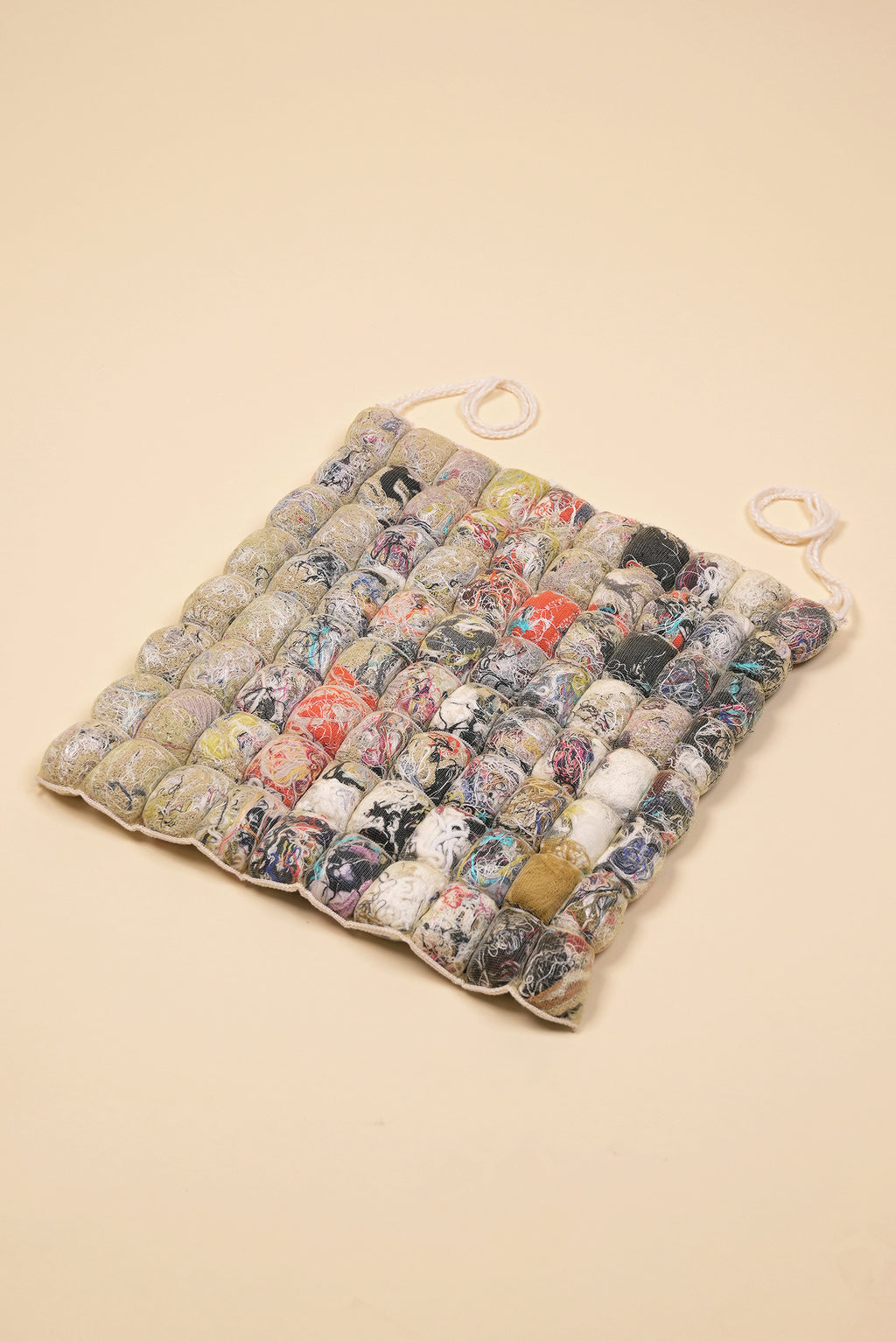 front view of knit seat cushion with transparent cover filled with upcycled materials