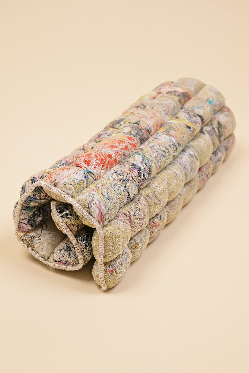 rolled up knit seat cushion with transparent cover filled with upcycled materials