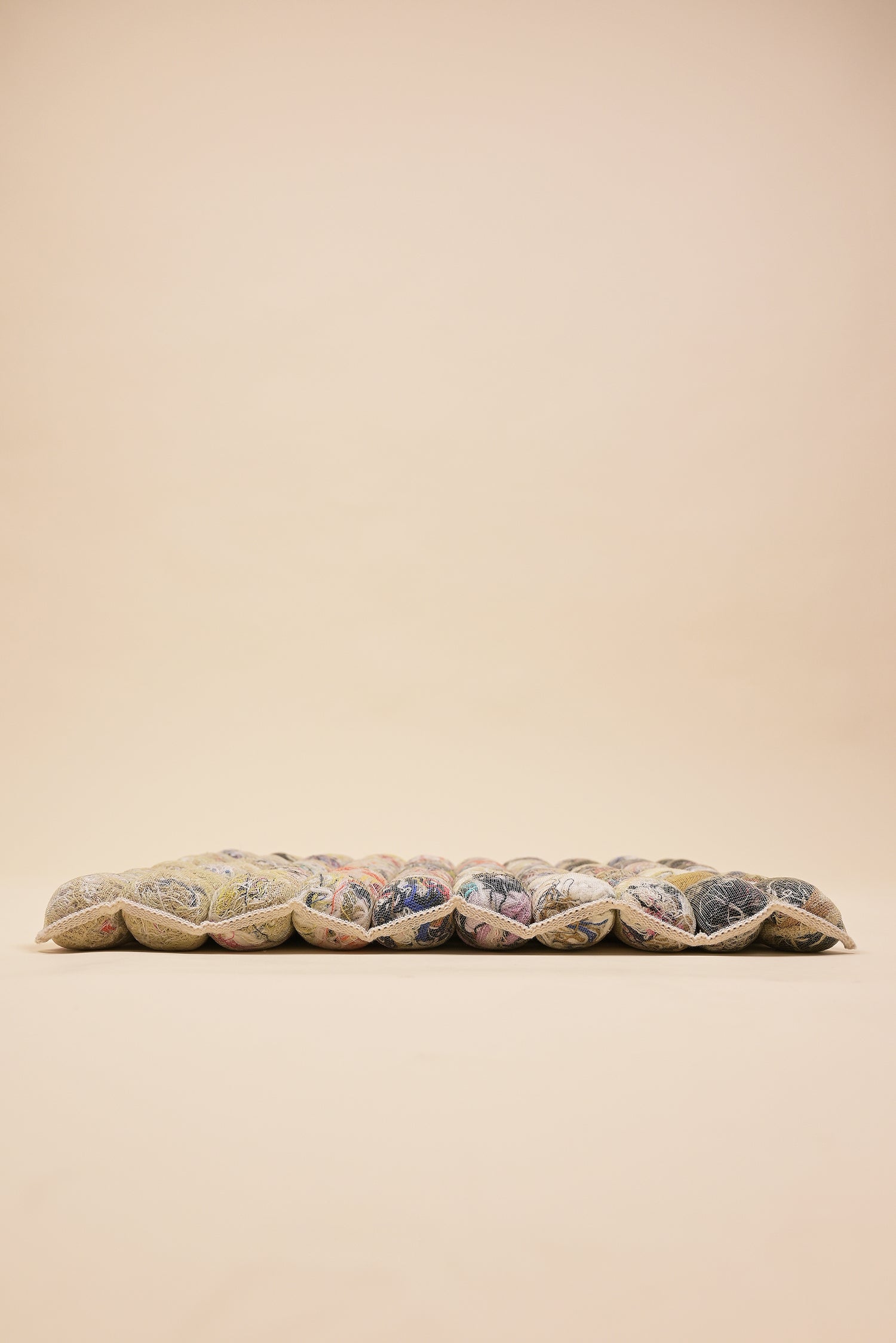 side view of knit seat cushion with transparent cover filled with upcycled materials