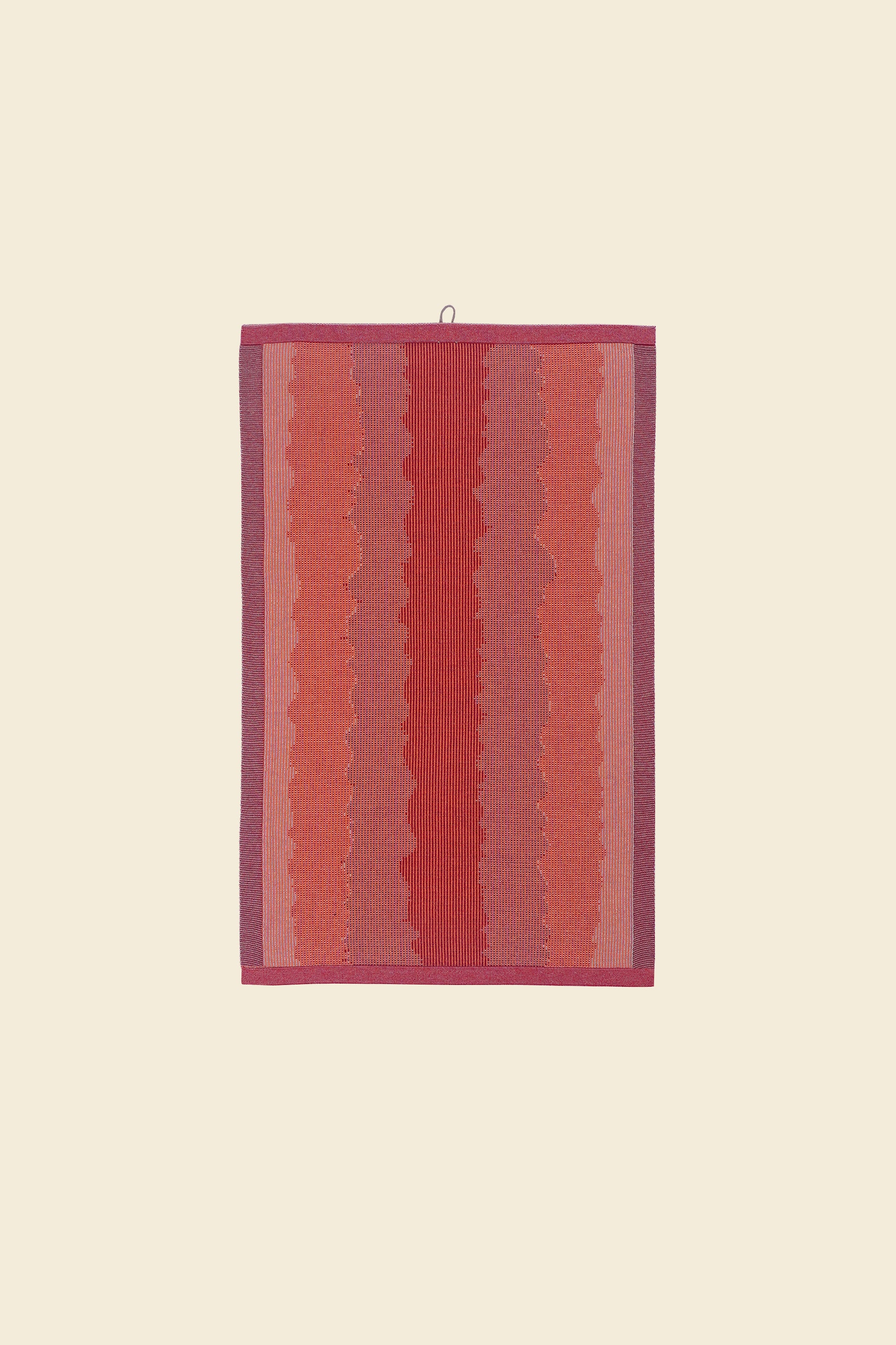 front view of red knit organic cotton kitchen towel with wavy pattern