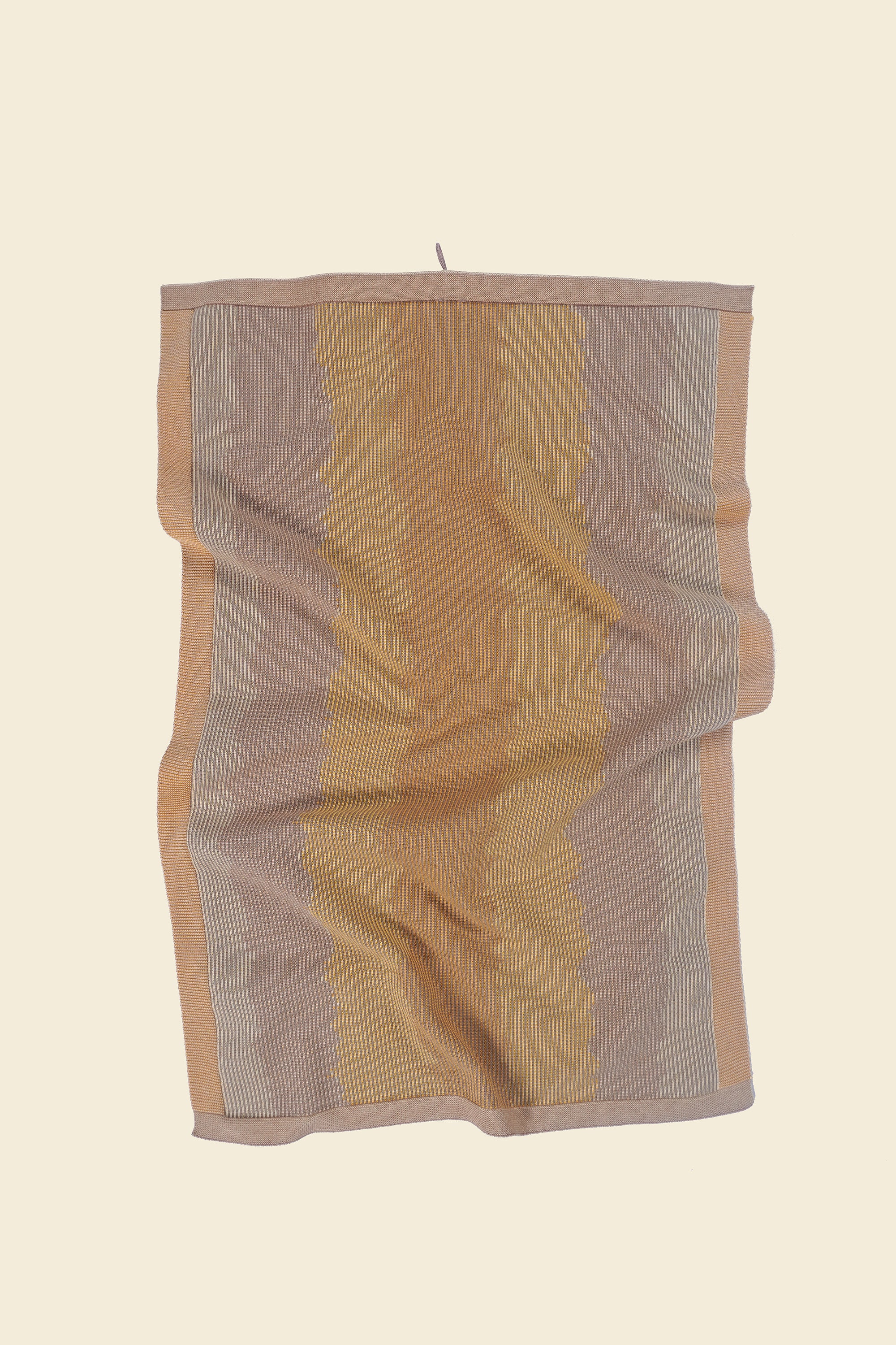 front view of yellow knit organic cotton kitchen towel with wavy pattern with folds