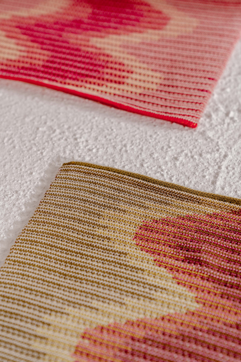 corner detail of red/gold knit table mat in organic cotton and viscose with wavy pattern