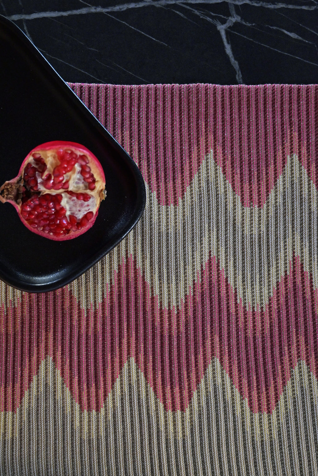 top detail of red/gold knit table mat in organic cotton and viscose with wavy pattern