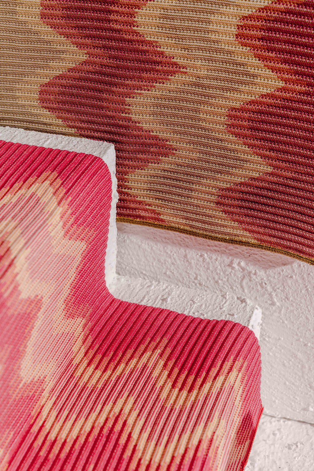 detail of red/yellow knit table mat in organic cotton and viscose with wavy pattern