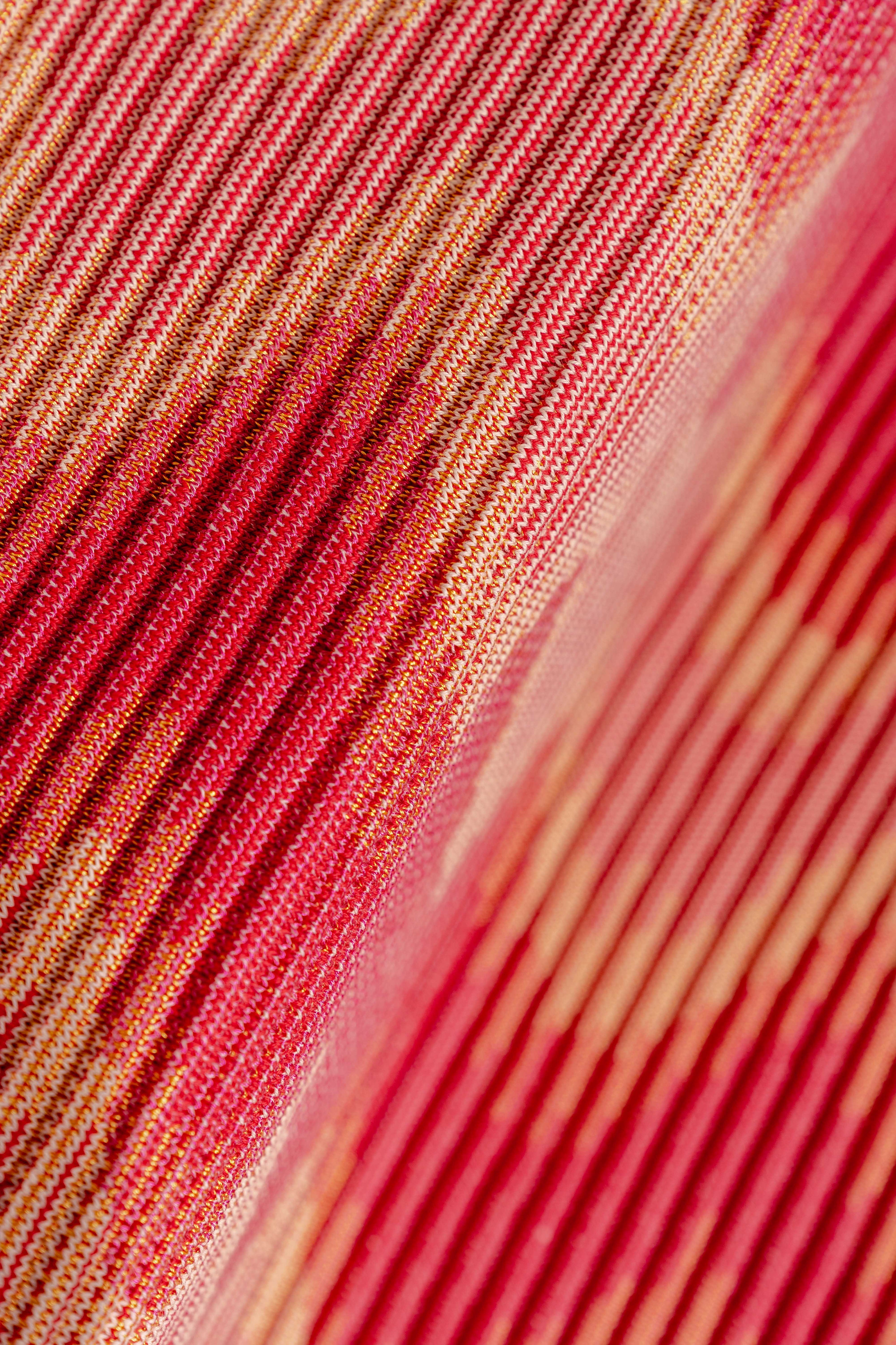 detail of red/yellow knit table mat in organic cotton and viscose with wavy pattern