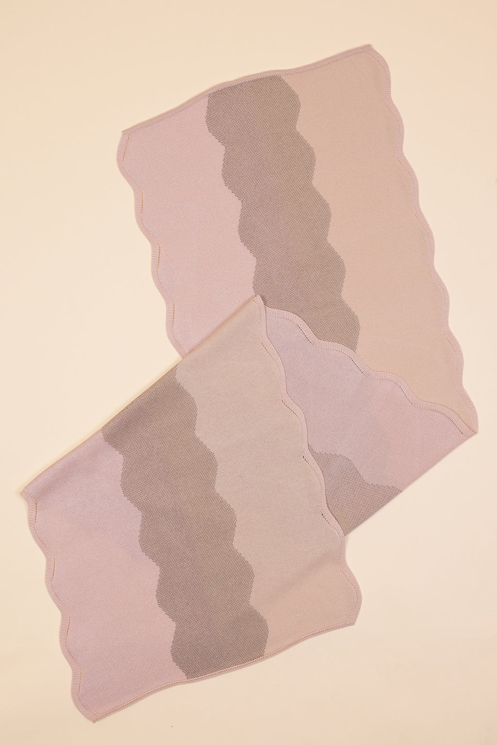 close-up folded view of wavy knit organic cotton table runner in pink  