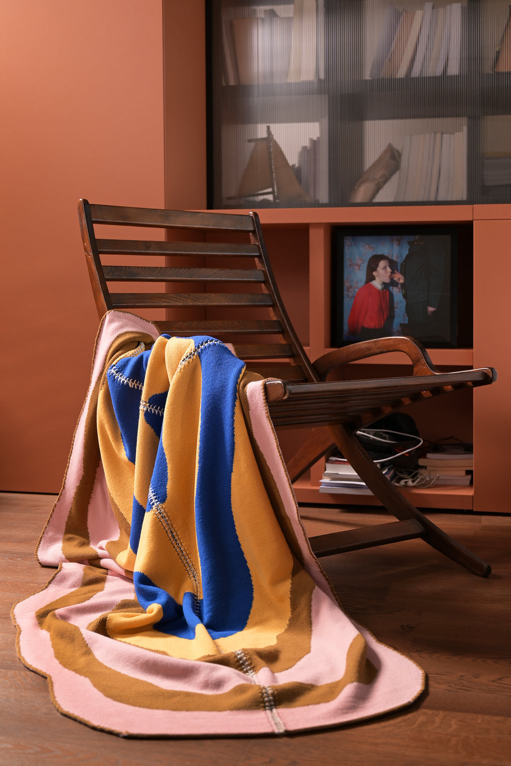 light wavy knit wool blanket on a chair with hand-stitched seam in blue, yellow, pink, and camel 