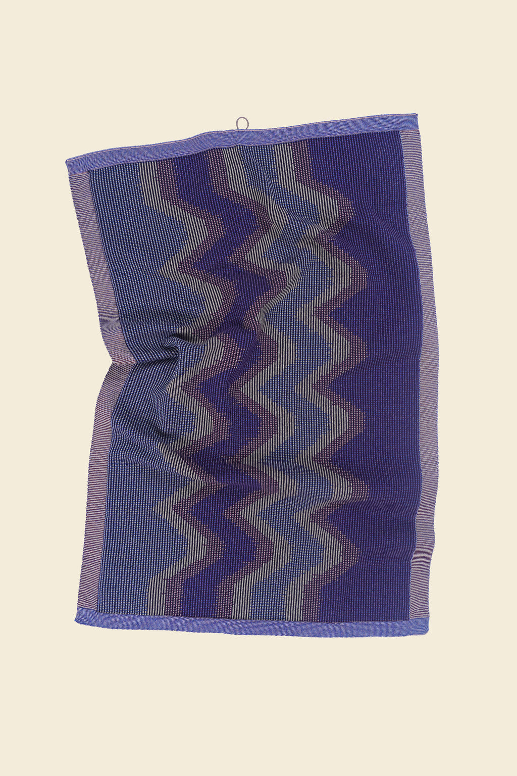 top view of purple knit organic cotton kitchen towel with zig zag pattern