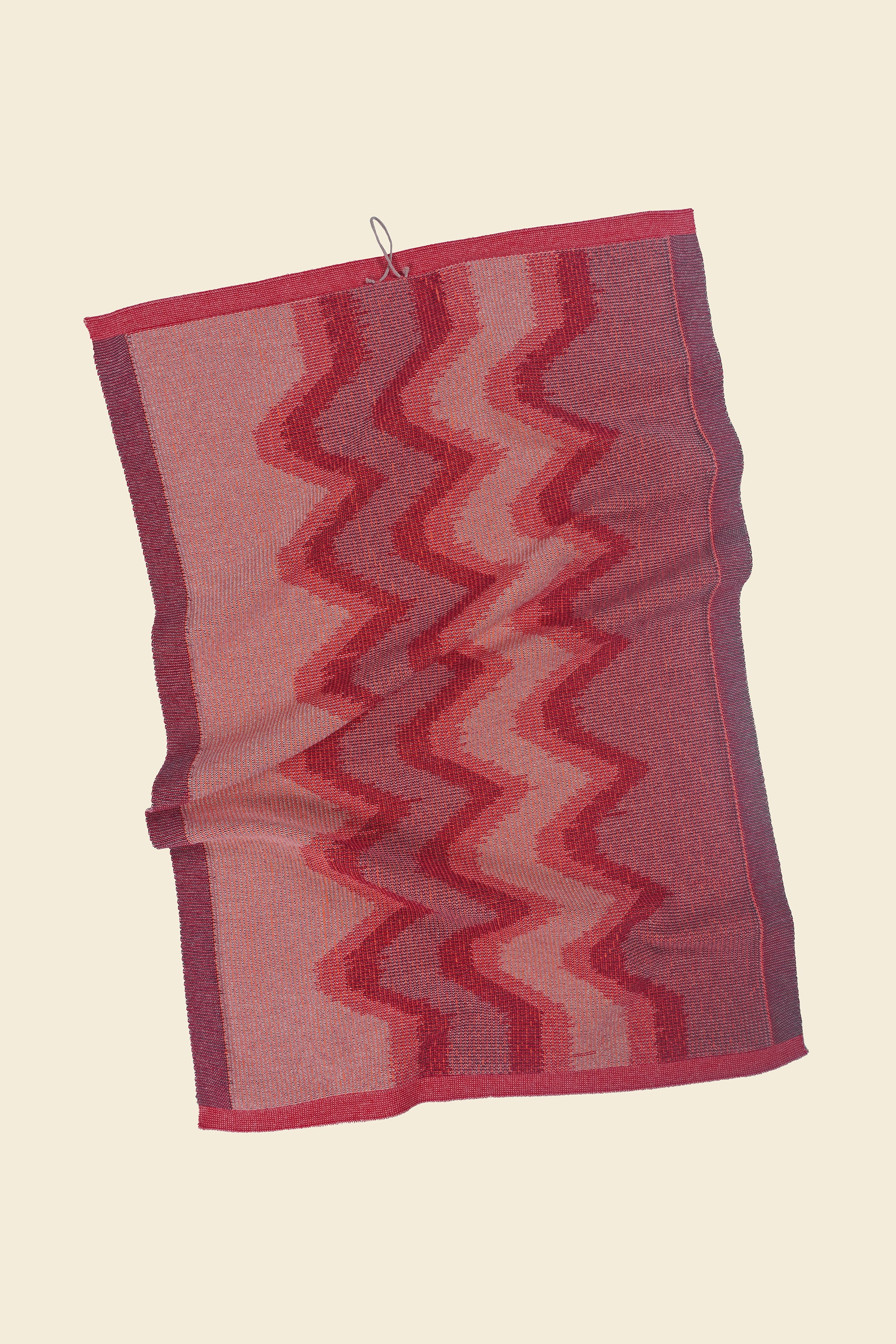 back side of red knit organic cotton kitchen towel with zig zag pattern